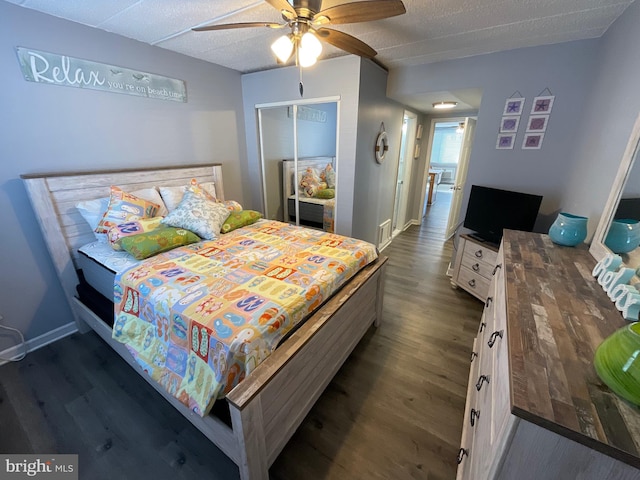 bedroom with a closet, visible vents, dark wood-type flooring, a ceiling fan, and baseboards