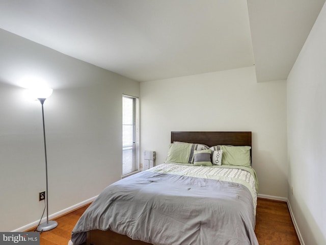 bedroom featuring baseboards and wood finished floors