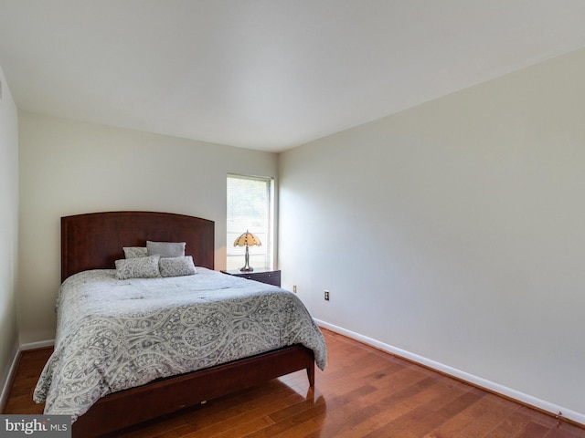 bedroom with wood finished floors and baseboards