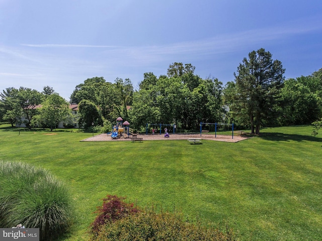 view of property's community featuring playground community and a lawn