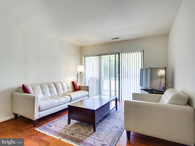 living room featuring visible vents and dark wood finished floors