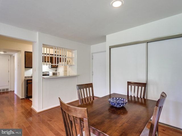 dining space with visible vents and wood finished floors