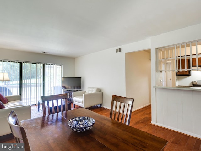 dining space with wood finished floors, visible vents, and baseboards