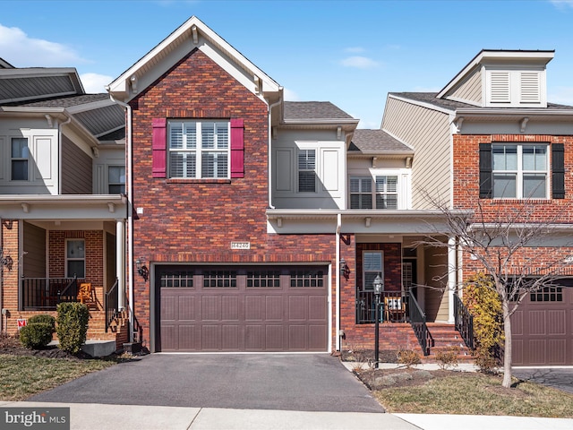 multi unit property featuring brick siding, an attached garage, a shingled roof, and aphalt driveway