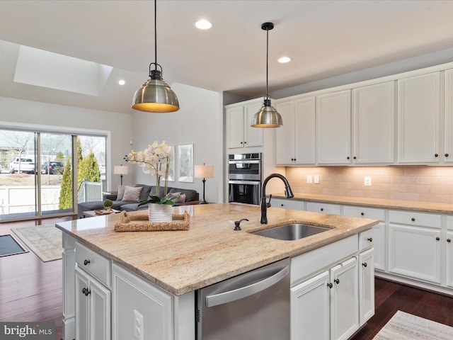 kitchen with recessed lighting, a sink, white cabinets, appliances with stainless steel finishes, and tasteful backsplash