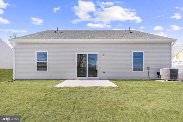 back of house featuring roof with shingles, a lawn, a patio area, and central air condition unit