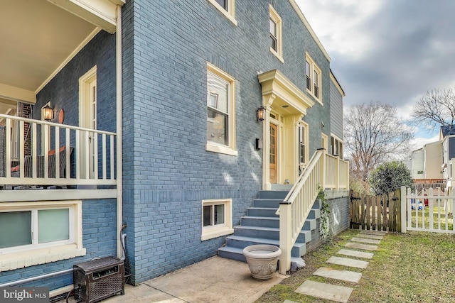 view of home's exterior featuring fence and brick siding