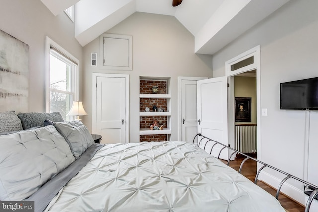 bedroom with visible vents, lofted ceiling, and dark wood-style flooring