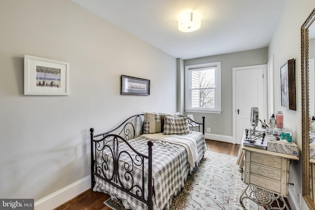 bedroom featuring baseboards and dark wood-type flooring