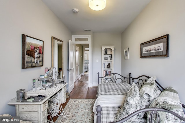 bedroom featuring visible vents, dark wood-type flooring, and baseboards