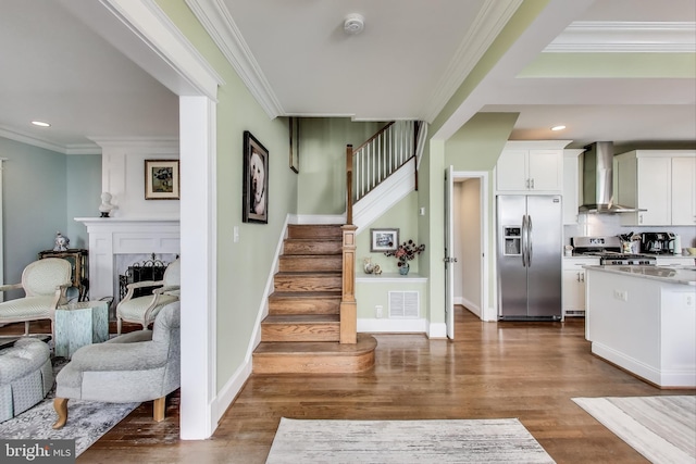 interior space featuring crown molding, wood finished floors, and visible vents