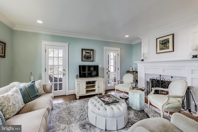 living area with recessed lighting, wood finished floors, baseboards, and ornamental molding