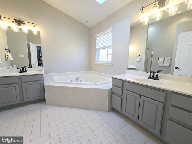 full bath featuring a bath, tile patterned floors, a sink, and lofted ceiling