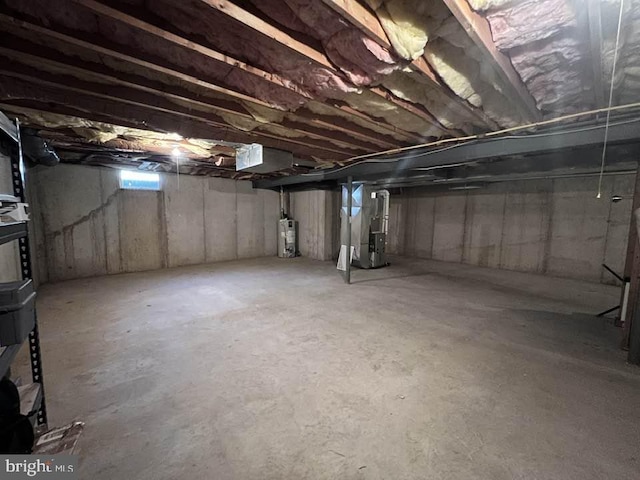 basement featuring electric water heater and heating unit