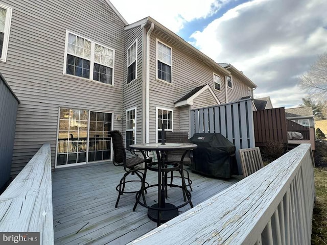 wooden terrace with grilling area and outdoor dining space