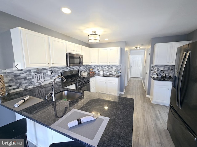 kitchen with gas stove, white cabinets, stainless steel microwave, and fridge with ice dispenser