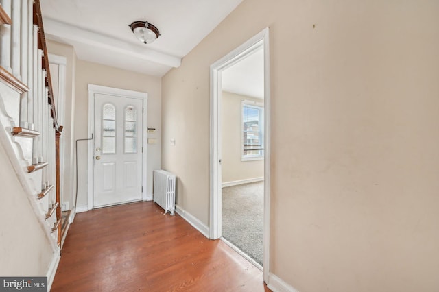 entryway with radiator, baseboards, and wood finished floors