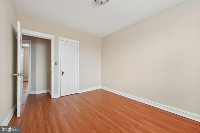 unfurnished bedroom featuring wood finished floors and baseboards