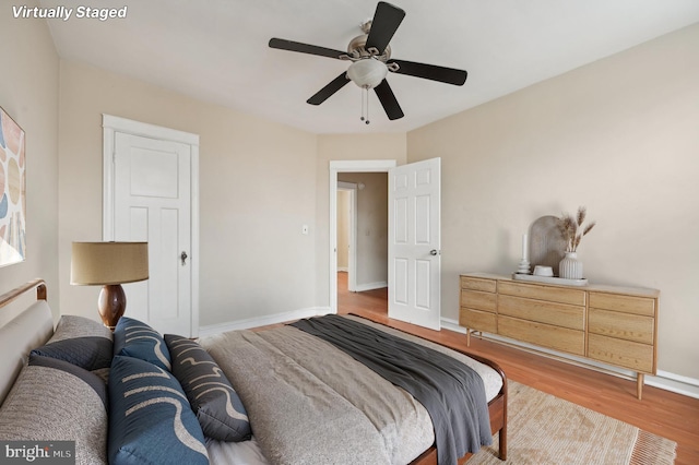 bedroom with ceiling fan, wood finished floors, and baseboards