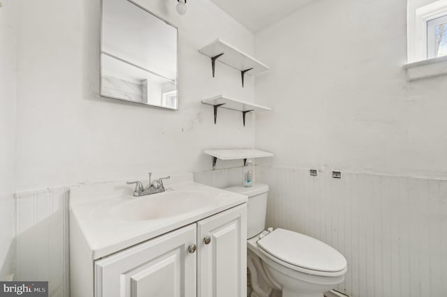 bathroom featuring wainscoting, vanity, and toilet