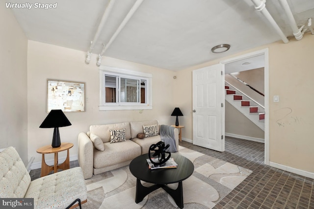 living area with baseboards and stairs