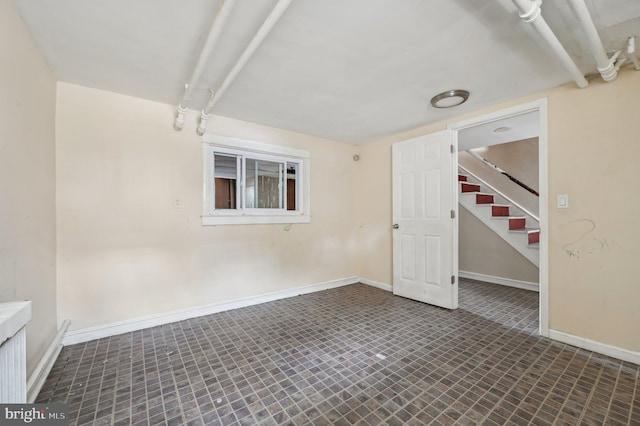 unfurnished room with stairs and baseboards