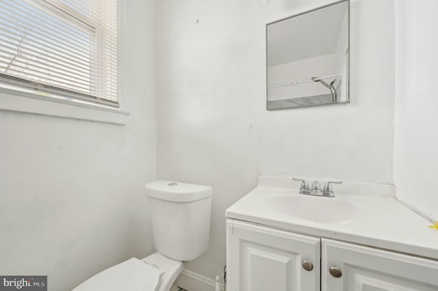 half bath featuring vanity and toilet