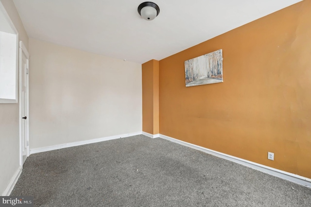 carpeted spare room featuring baseboards