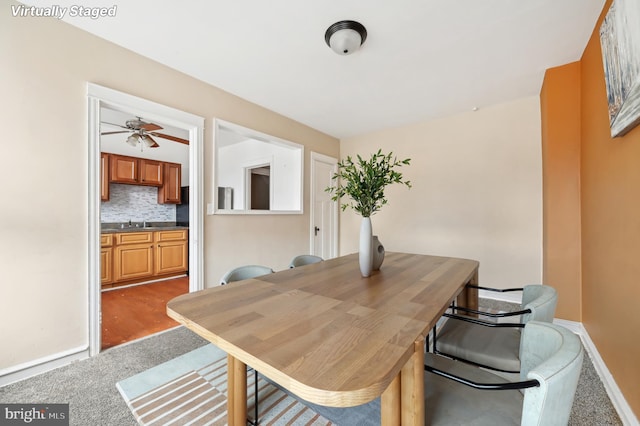 carpeted dining space with baseboards