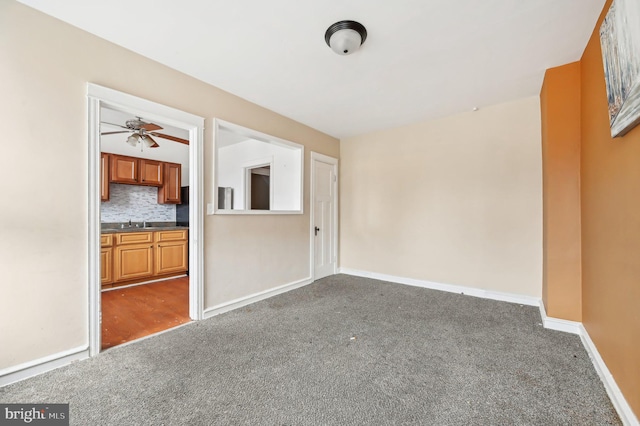 empty room featuring dark colored carpet and baseboards