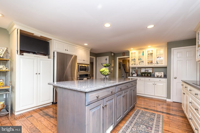 kitchen with recessed lighting, gray cabinetry, stainless steel appliances, a kitchen island, and white cabinets