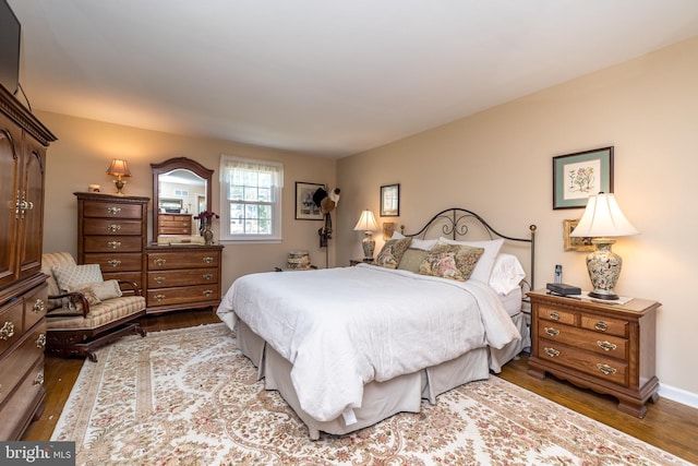 bedroom featuring baseboards and dark wood-type flooring