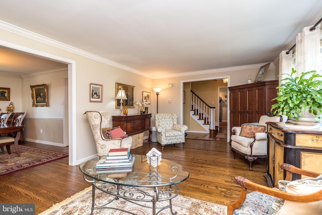 living room featuring ornamental molding, wood finished floors, baseboards, and stairs