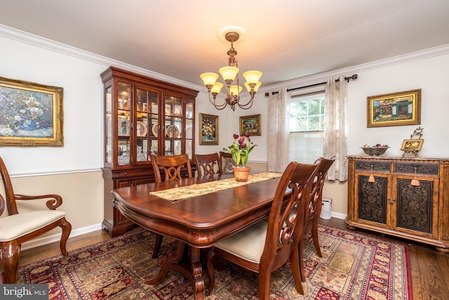 dining area with a chandelier, dark wood-type flooring, baseboards, and crown molding