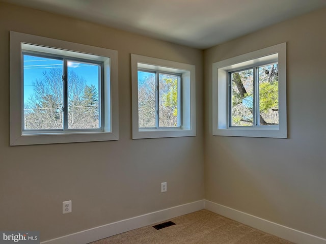 unfurnished room featuring carpet, baseboards, and visible vents