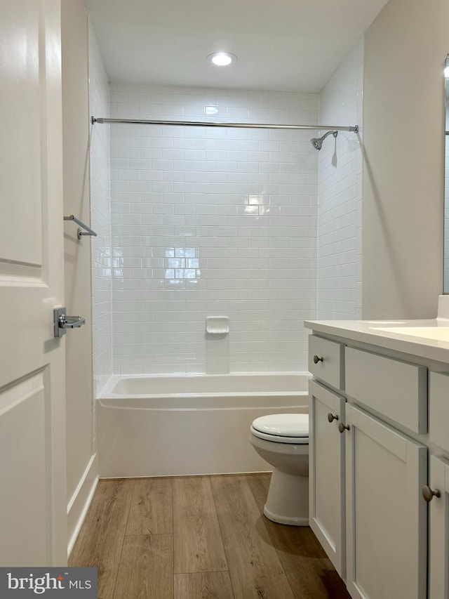 bathroom featuring vanity, bathing tub / shower combination, toilet, and wood finished floors