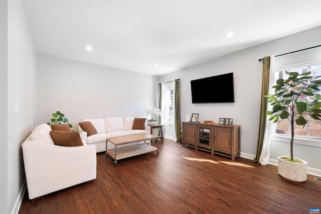 living area with dark wood finished floors, plenty of natural light, baseboards, and recessed lighting