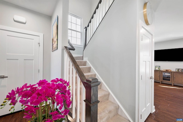 stairs with wood finished floors and baseboards