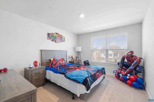 bedroom featuring light carpet and baseboards