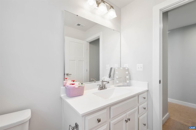 bathroom with visible vents, toilet, vanity, and baseboards