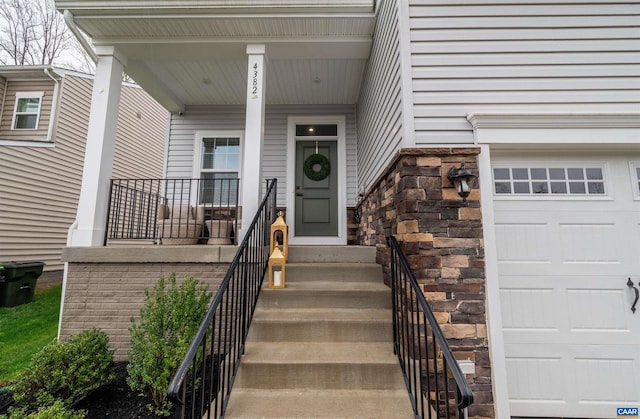 view of exterior entry featuring a garage and stone siding