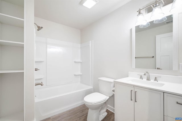 full bath with visible vents, toilet, washtub / shower combination, vanity, and wood finished floors