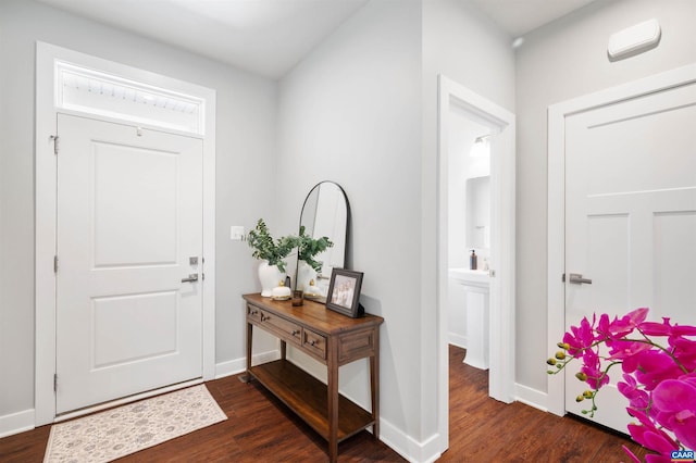 foyer with dark wood finished floors and baseboards