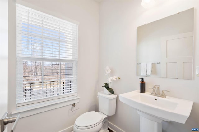 bathroom featuring a sink, toilet, and baseboards