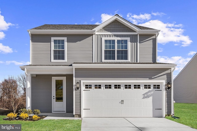 view of front of home featuring board and batten siding, concrete driveway, a front lawn, and an attached garage