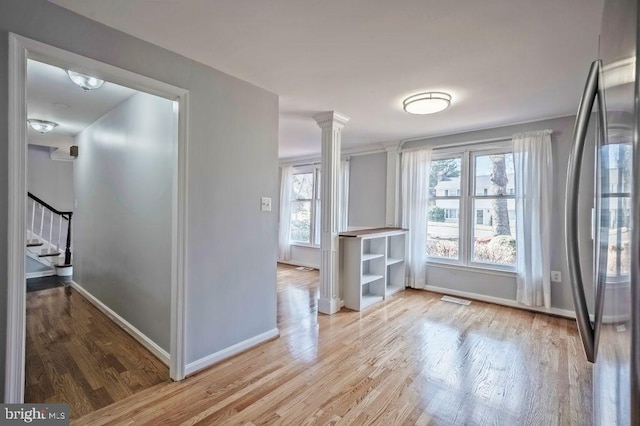 doorway with ornate columns, stairs, baseboards, and wood finished floors