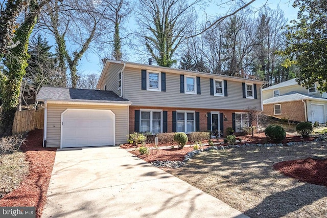 colonial inspired home featuring driveway, brick siding, an attached garage, and fence