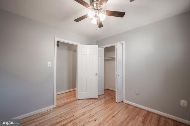 unfurnished bedroom with a closet, visible vents, baseboards, and wood finished floors