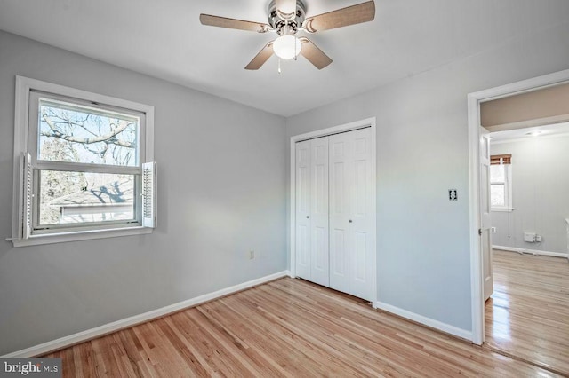 unfurnished bedroom with a ceiling fan, a closet, baseboards, and light wood finished floors