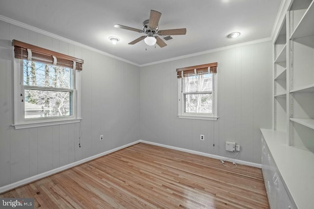 empty room featuring baseboards, ornamental molding, light wood-style flooring, and a ceiling fan